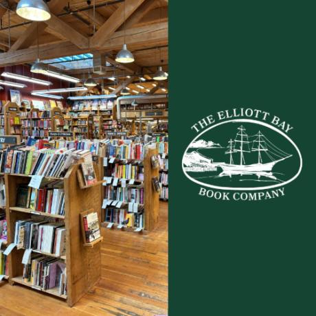Inside Elliott Bay Book Company, rows of wooden shelves stretch across a large room.