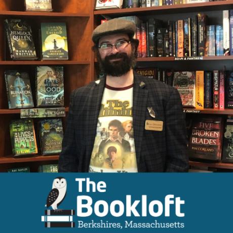 The Bookloft owner, Giovanni Boivin, stands in front of a bookshelf.