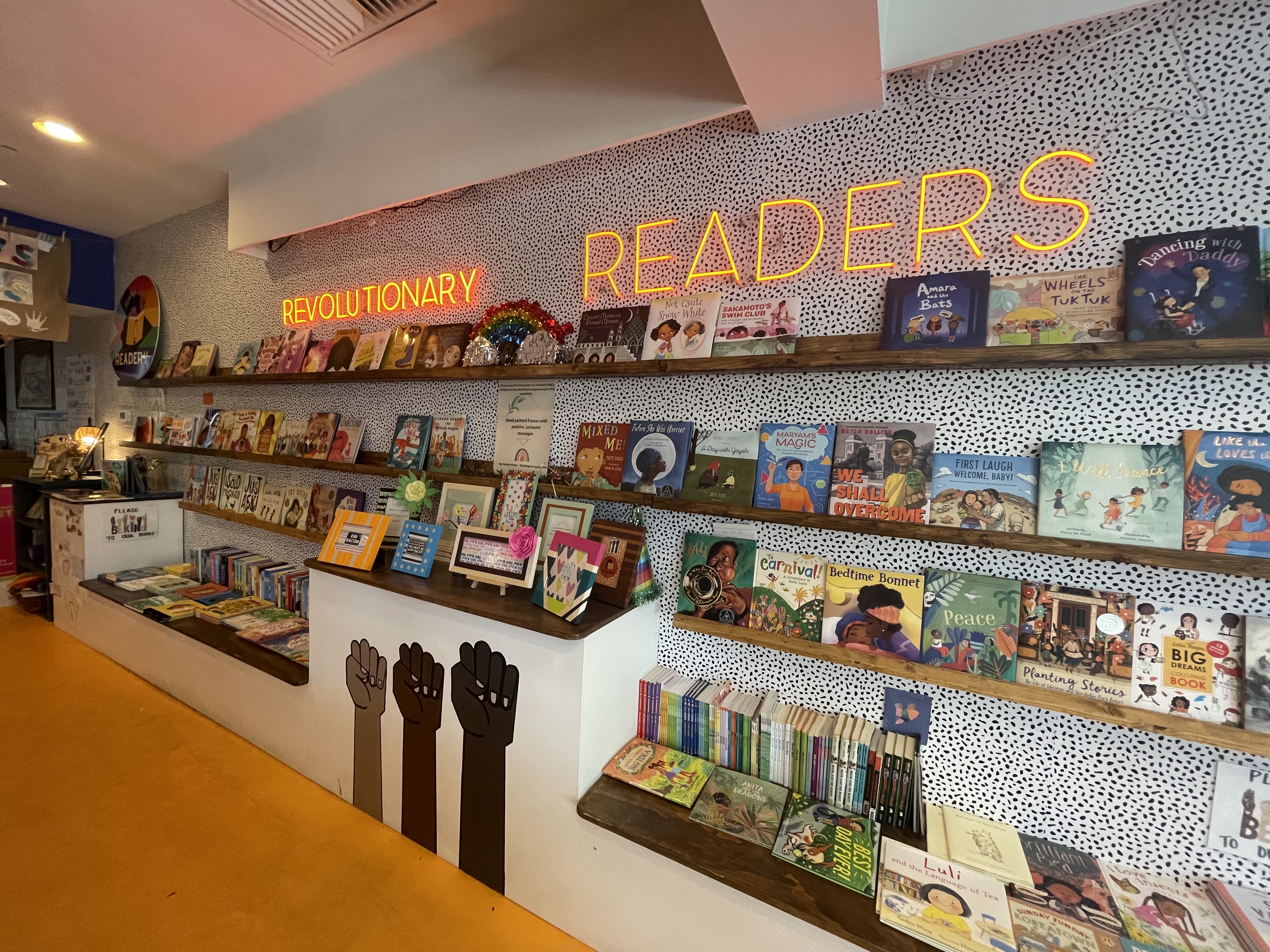 A wall of books with a neon sign that says "Rohi's Readery."