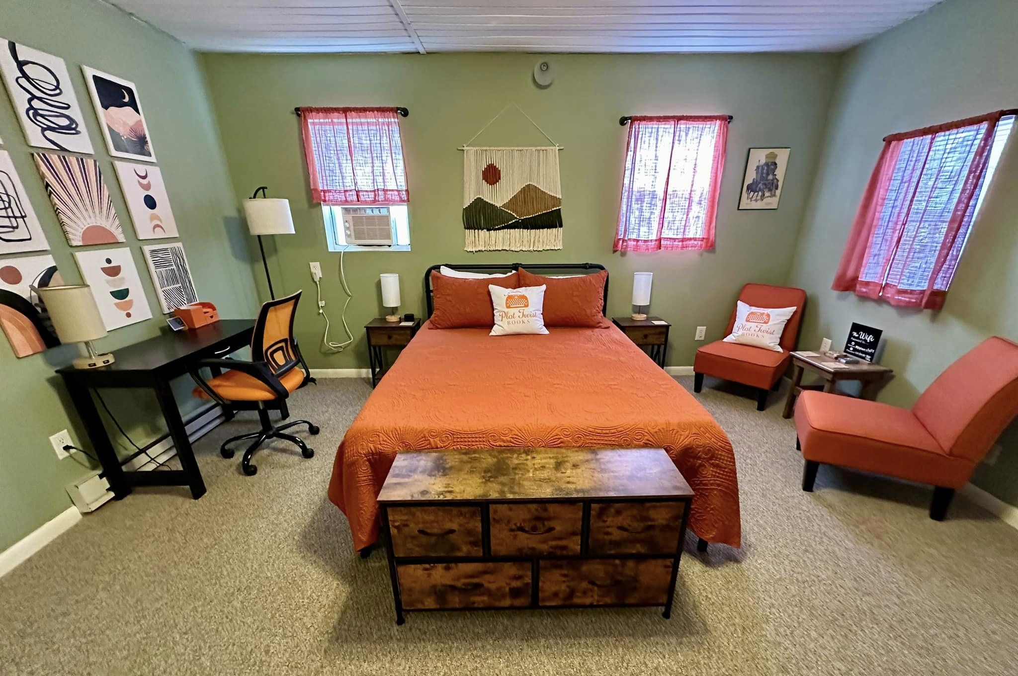 The bedroom at Plot Twist Books contains a bed, desk, and chairs for guests.